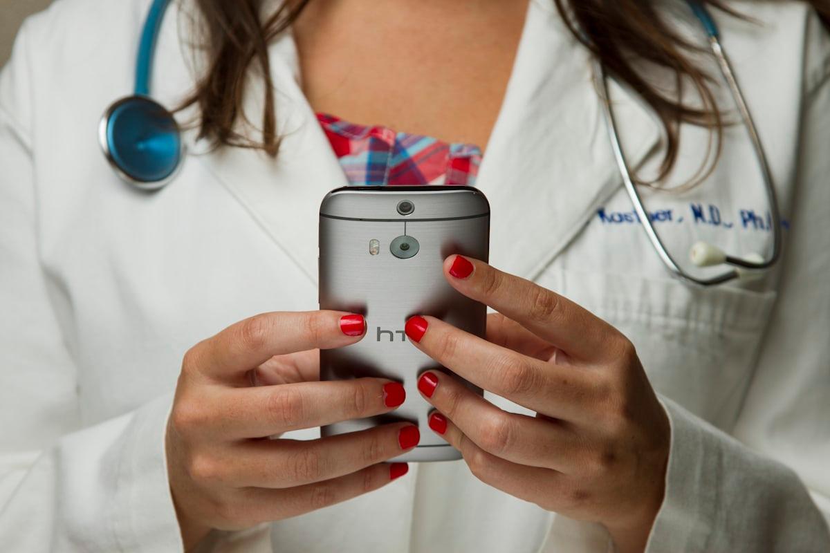 Profissional de saúde usando o smartphone no corredor do hospital